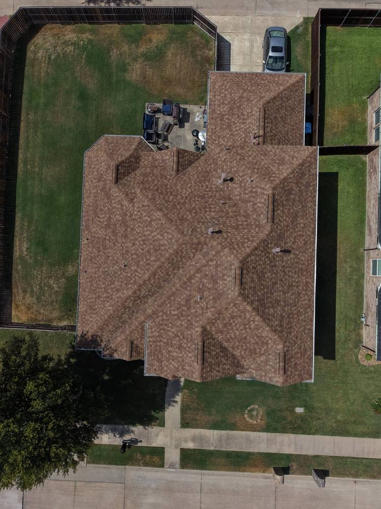 Top-down drone view of a completed brown architectural shingle roof