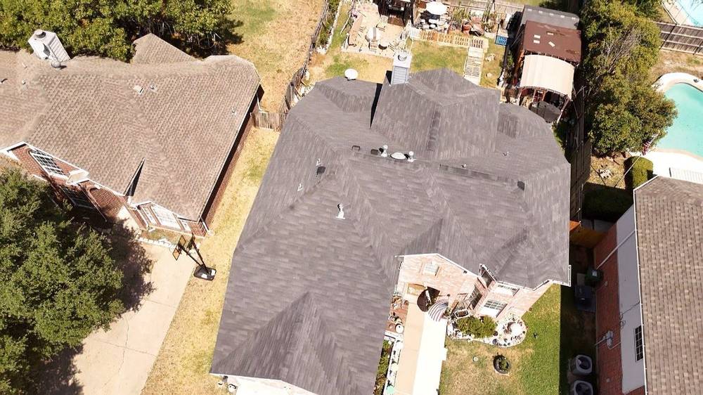 Dark architectural shingle roof on a home with a backyard pool, aerial