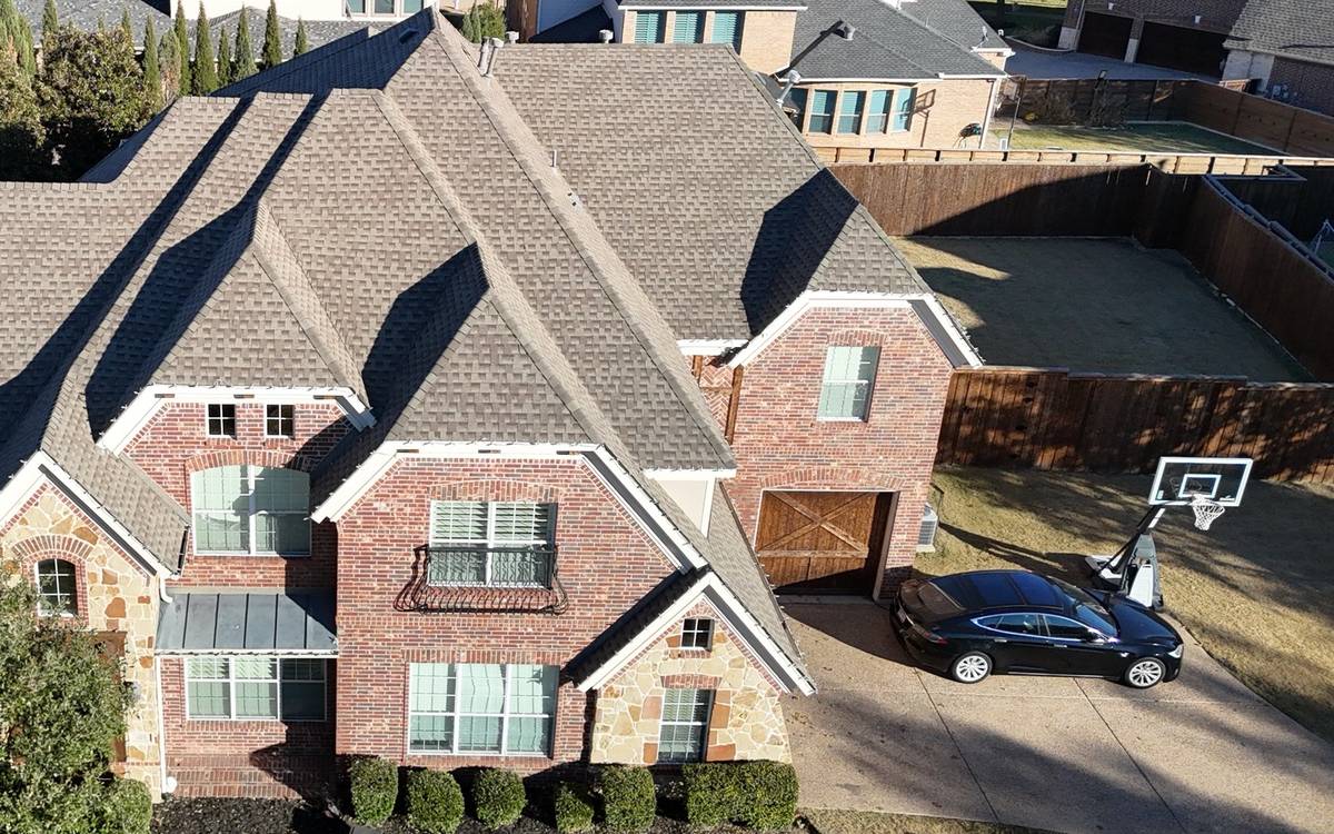 Brick two-story home with its old gray shingle roof, drone photo from our inspection in December 2025