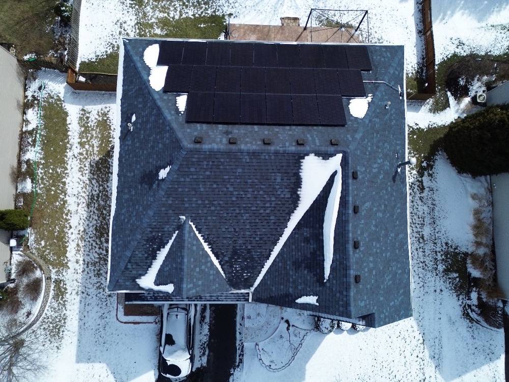 Top-down drone view of a hip roof with rooftop solar in Bolingbrook, IL, after snowfall
