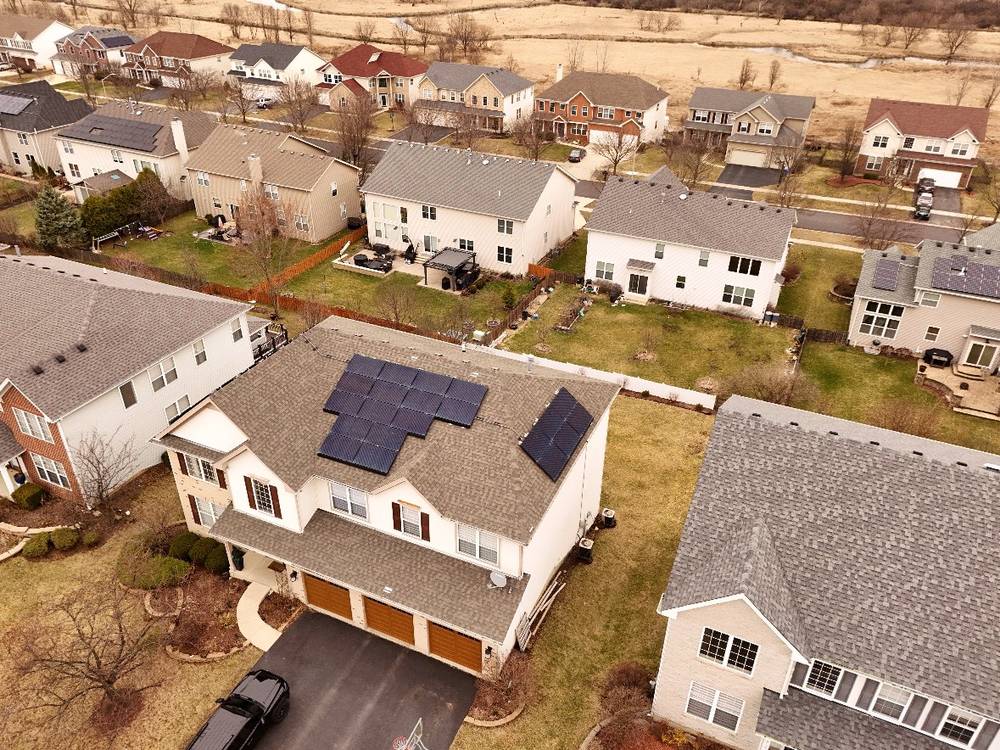Architectural shingle roof with rooftop solar on a two-story home in Bolingbrook, IL, neighborhood aerial