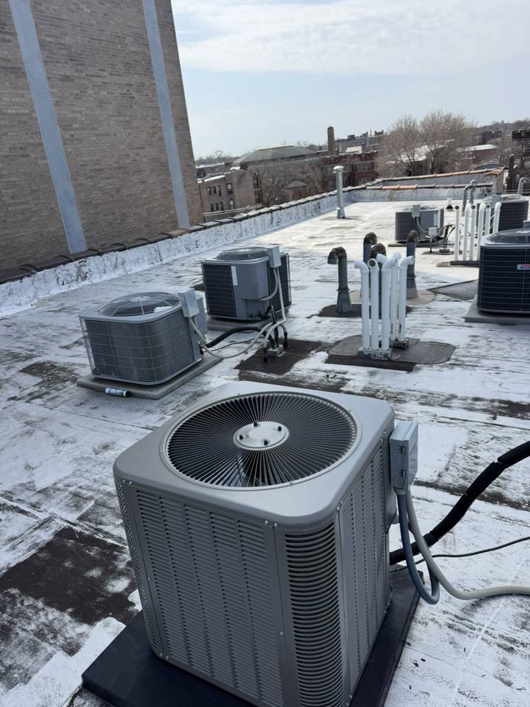 Commercial coated flat roof with rooftop HVAC condensers and vent stacks in Chicago, IL