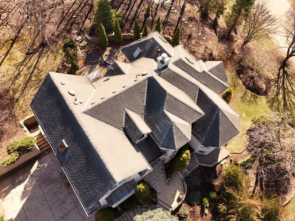 Large gray-shingle multi-gable roof in Hinsdale, IL, overhead drone aerial