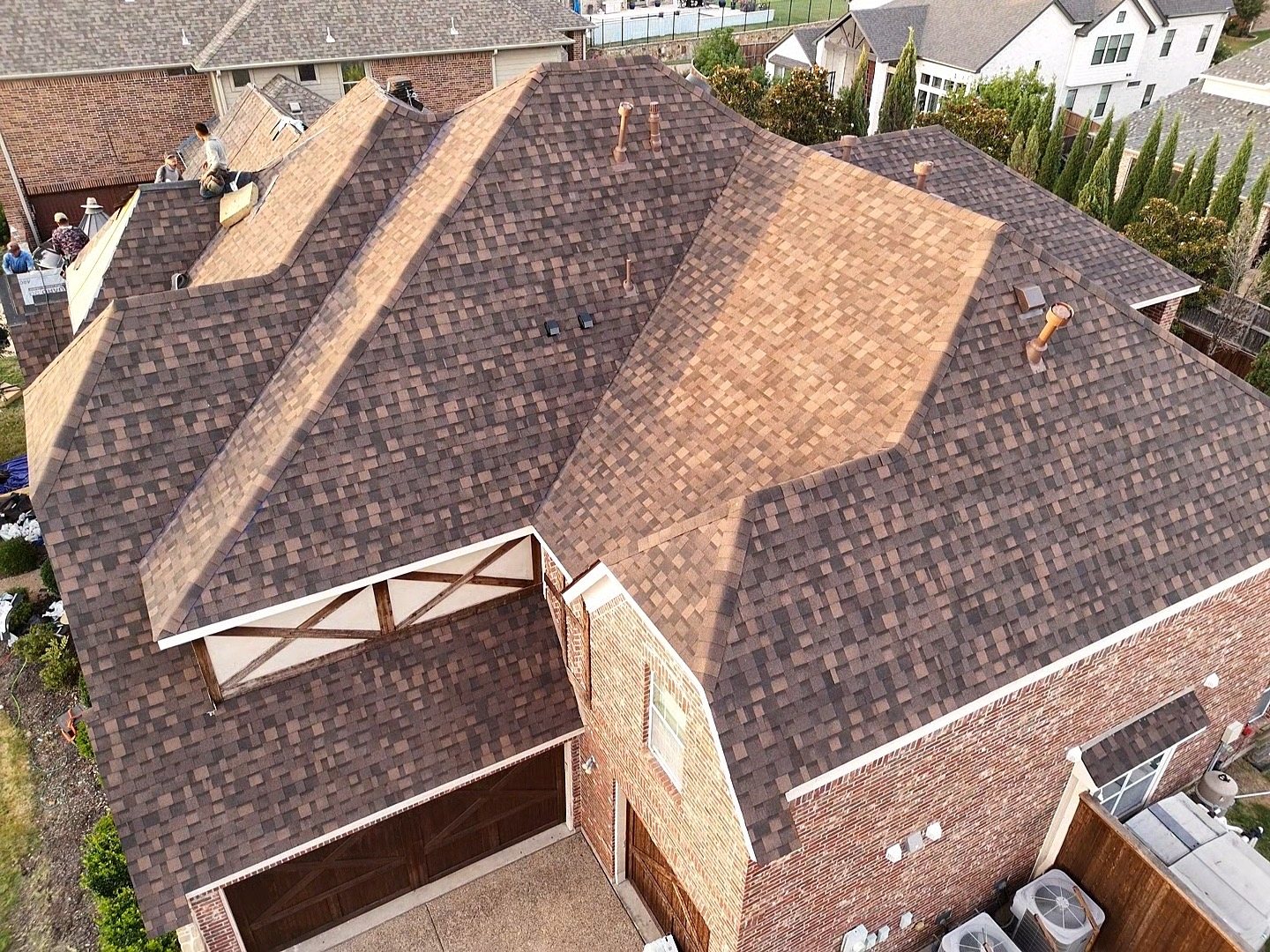 Roof tear-off in progress with debris tarped and staged