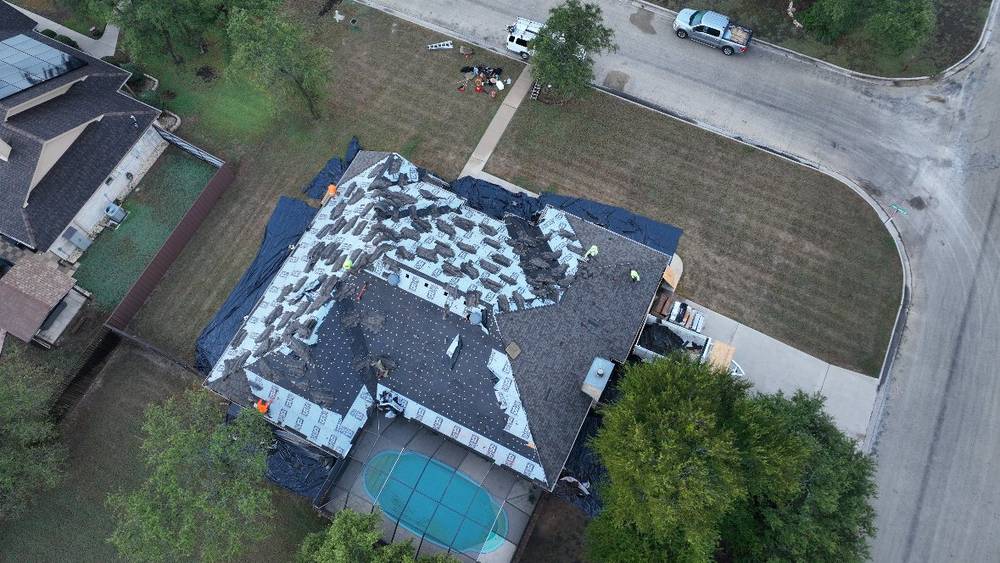 Roof tear-off in progress on a home with a screened pool