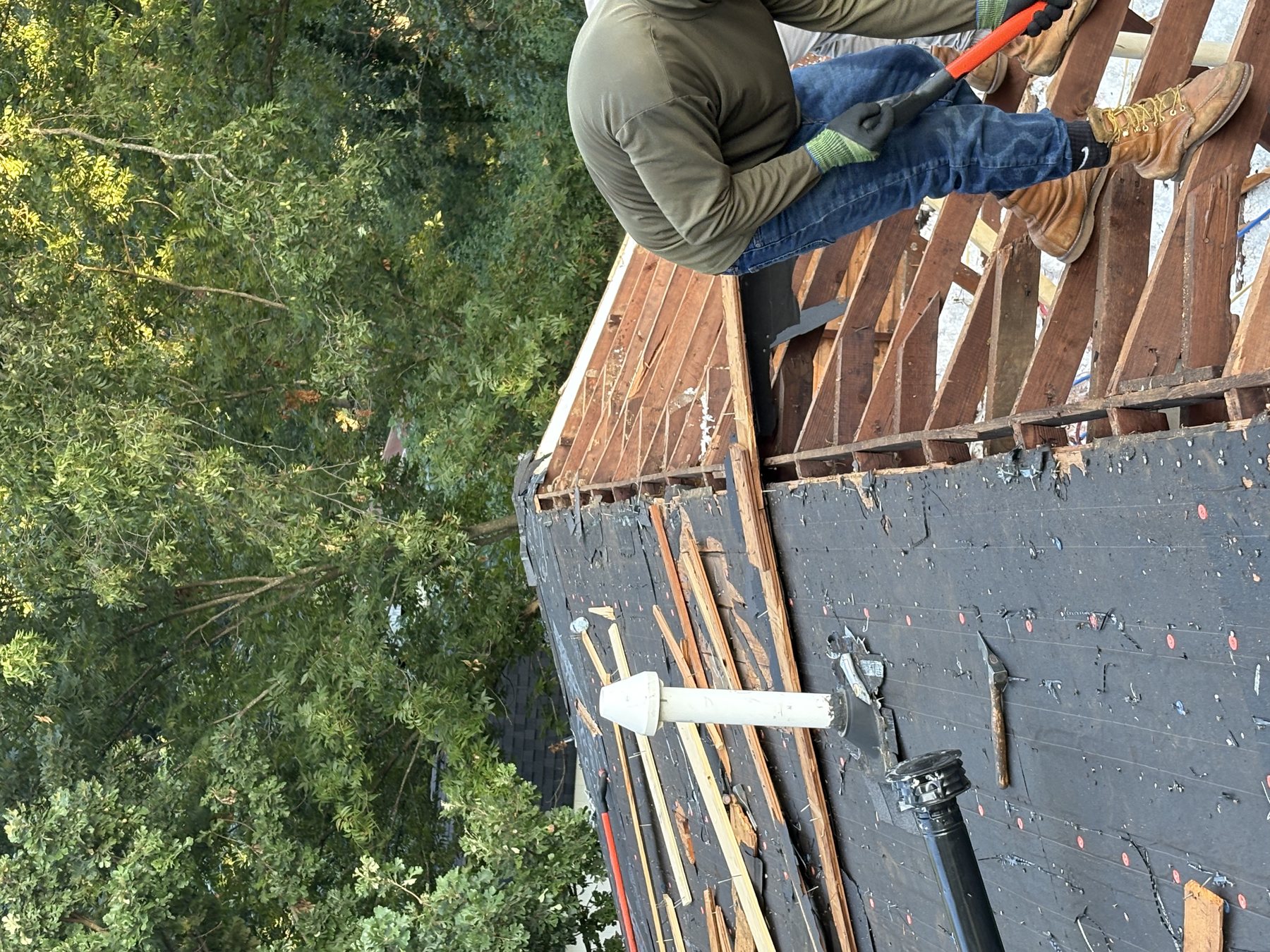 Roofing crew tearing an old roof down to the decking after storm damage