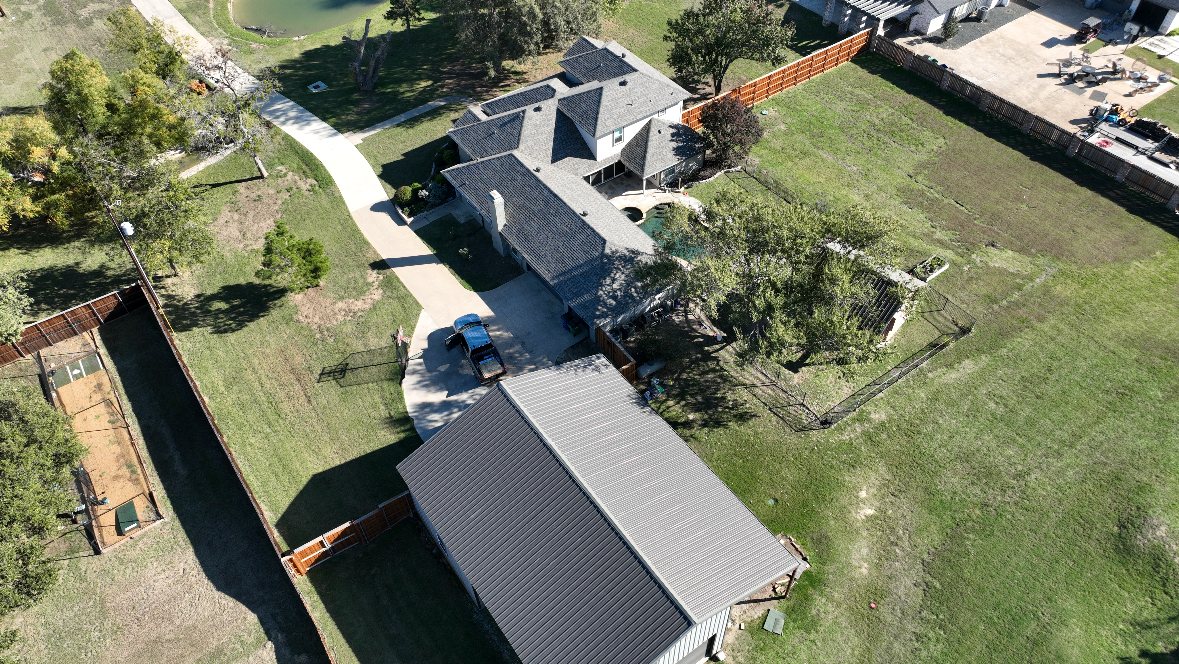 Roof tear-off in progress with debris tarped and staged